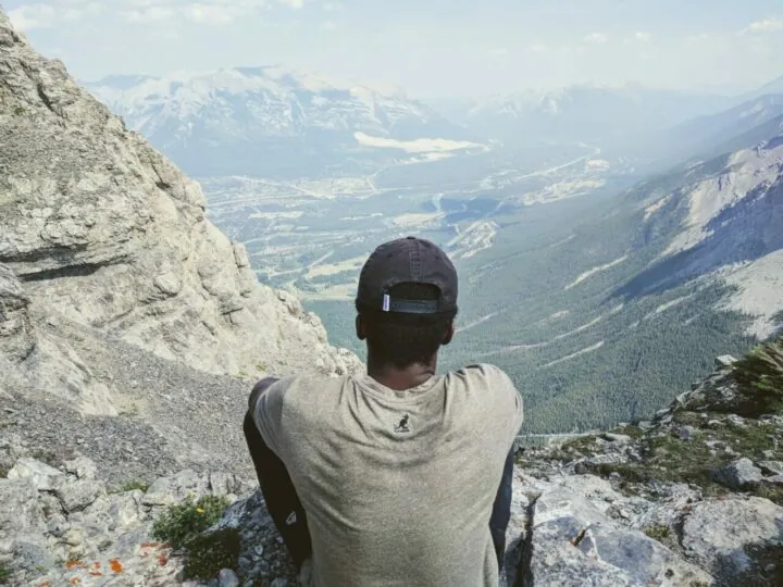 Stephan, sitting on a mountain ledge looking out over a valley