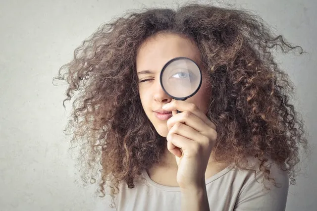 woman-looking-through-magnifying-glass