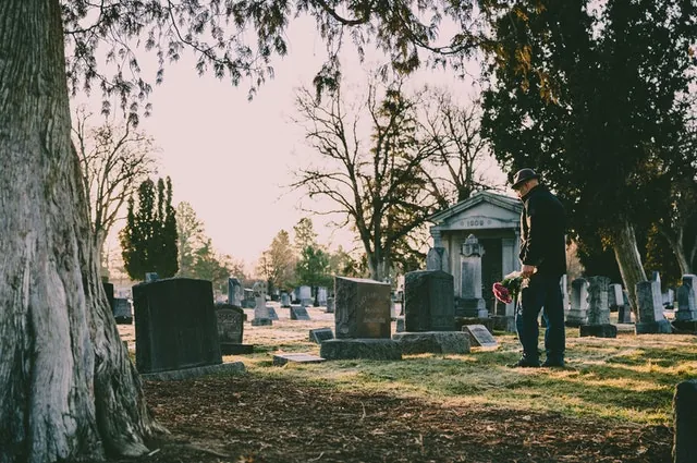 man-standing-in-front-of-grave