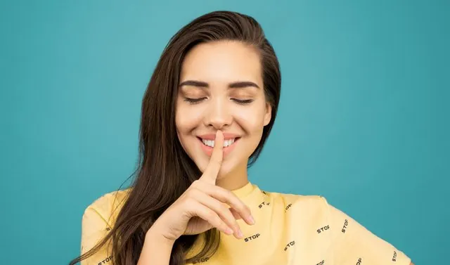 woman-holding-finger-to-mouth